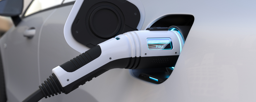 Ein Elektroauto wird an einer Ladesäule aufgeladen. Das leuchtende Display zeigt den vollen Ladezustand an. Das Bild symbolisiert steuerfreie Arbeitgeberleistungen für das Aufladen von E-Autos, E-Bikes oder E-Rollern gemäß § 3 Nr. 46 EStG.